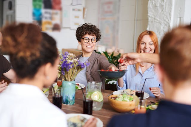 A group of woman sitting around a table enjoying dinner