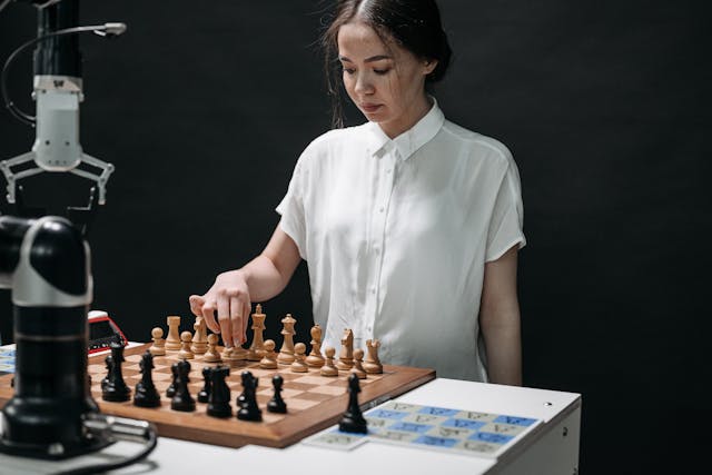 A woman contemplates a chess move playing against a machine
